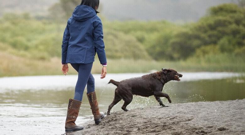 woman walking with dog in water
